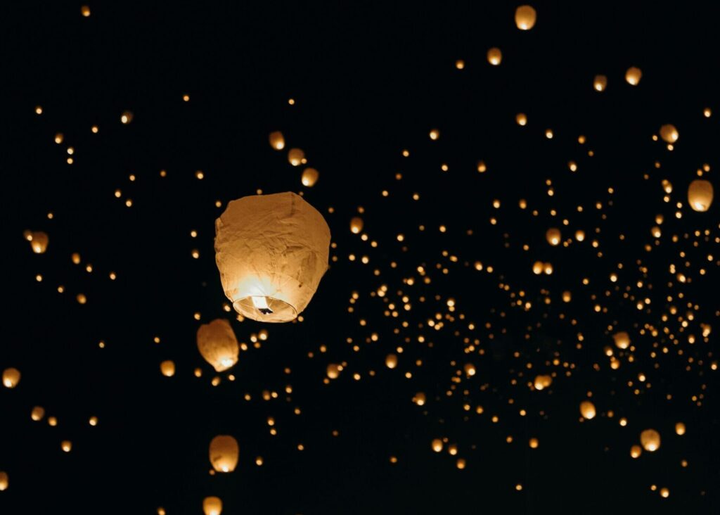 Lit paper lanterns being released into the night sky