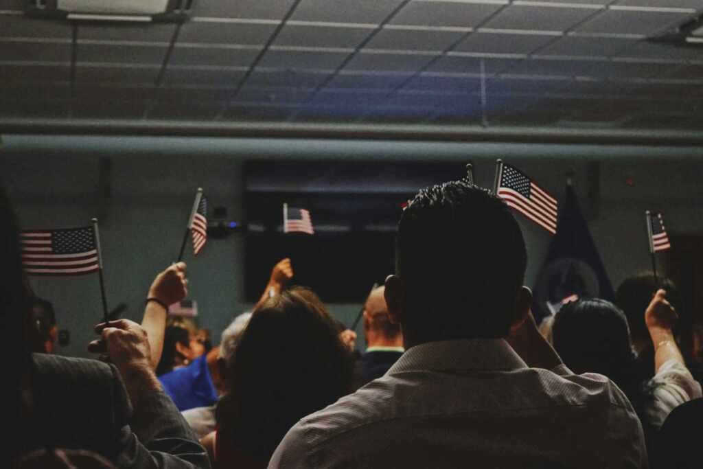 a room of people holding up small American flags