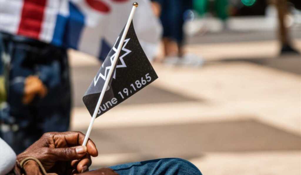 Hand holding a Juneteenth flag