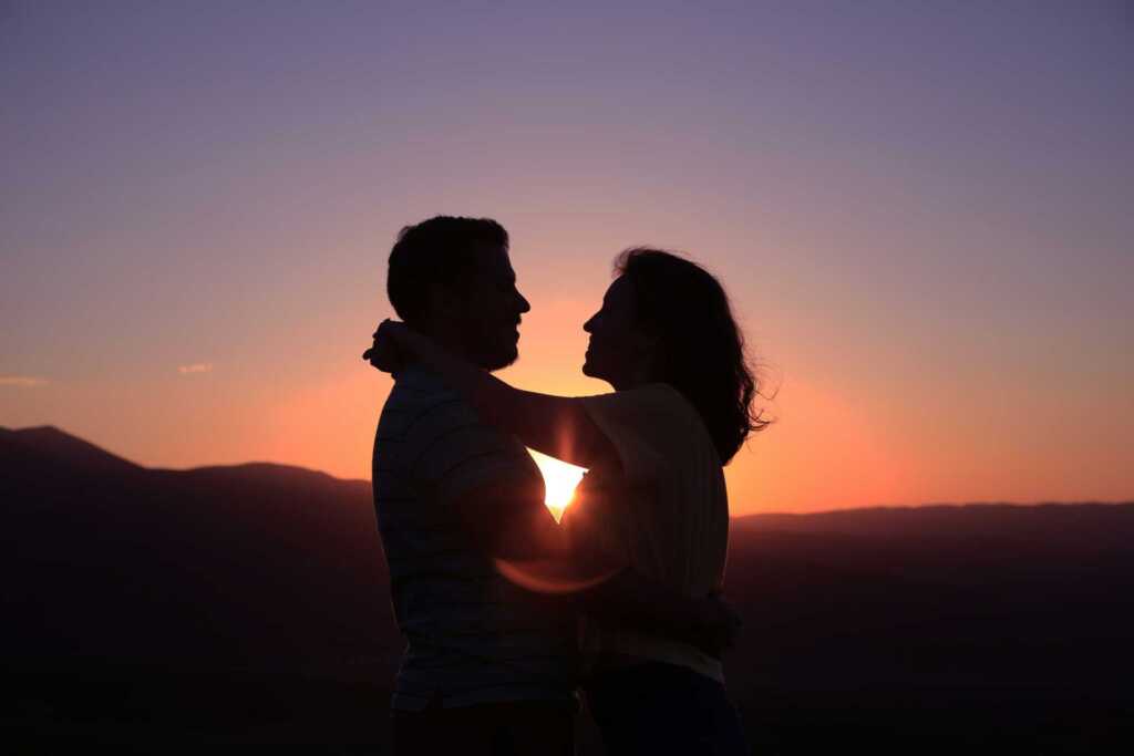 A couple silhouetted by the sunset