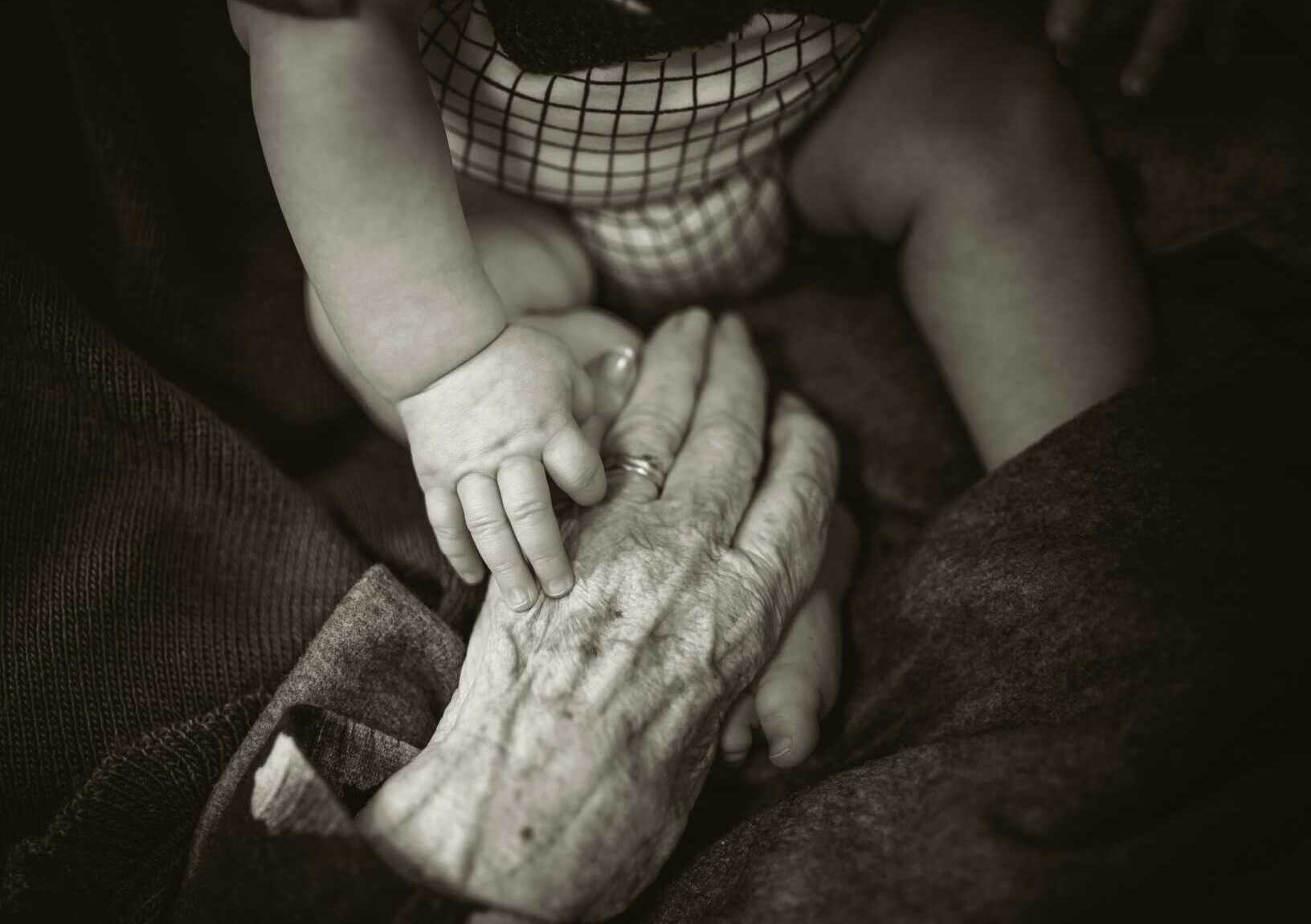 rod long y0OAmd COUM unsplash a black and white photo of a baby sitting across from a grandparent