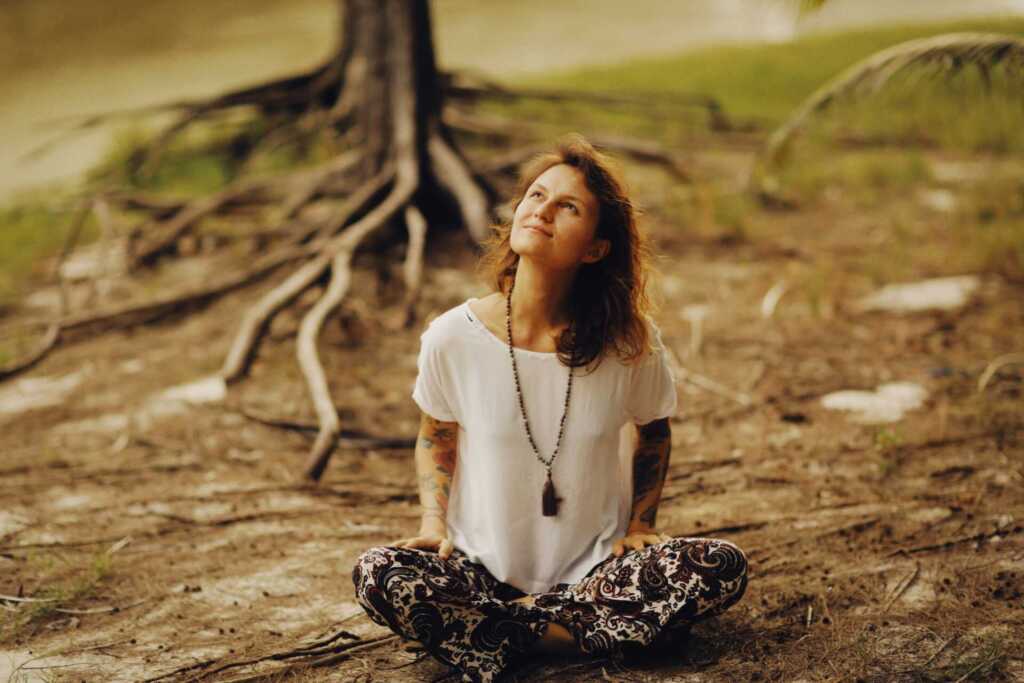 A woman sitting cross-legged and looking up