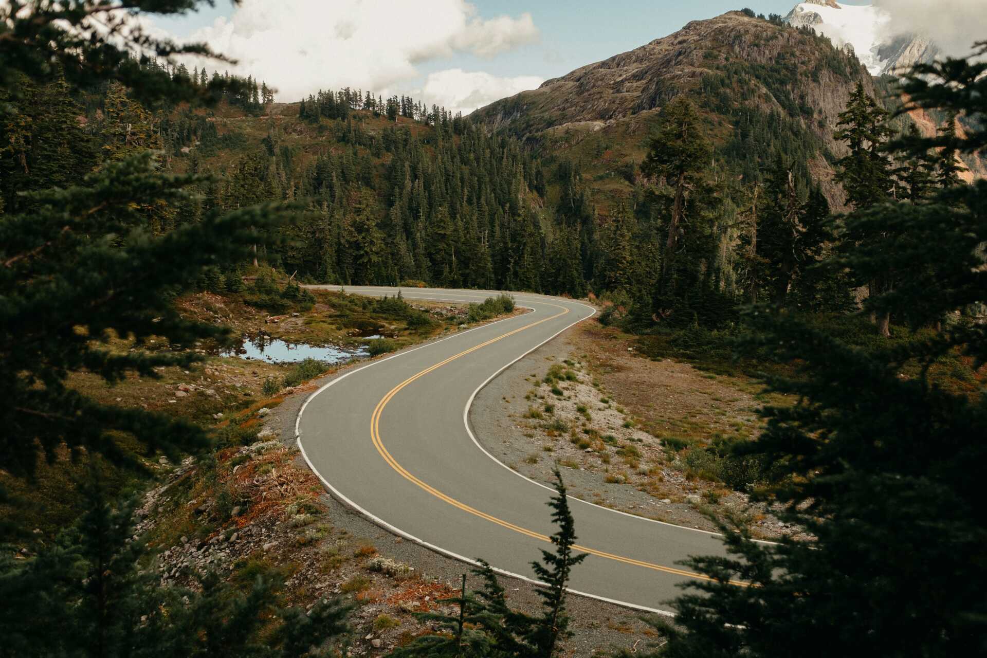 brandon burridge q3GqybtTv7E unsplash A road winding through the mountains and forest