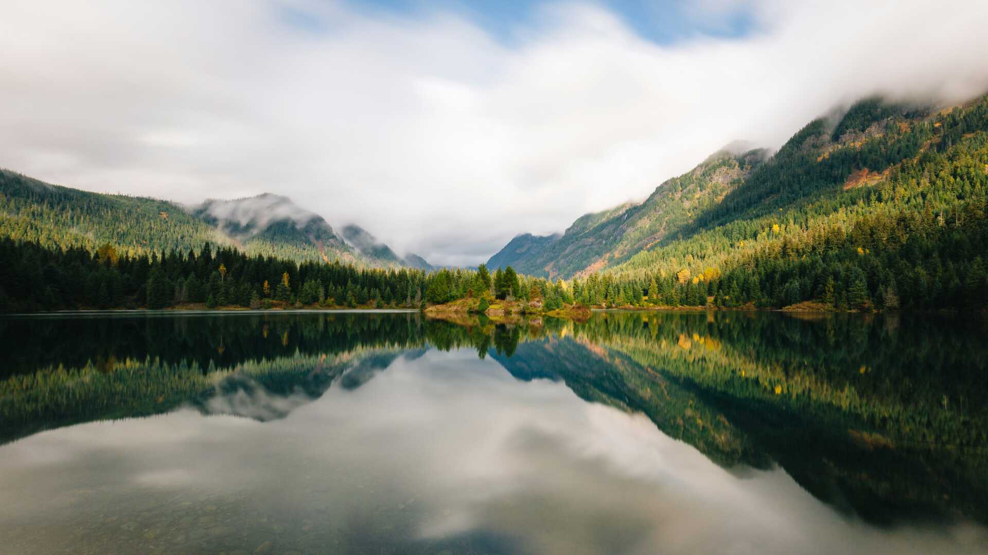 dave hoefler WmqzZ ARvN4 unsplash A view of a lake with mountains on the other side under fog