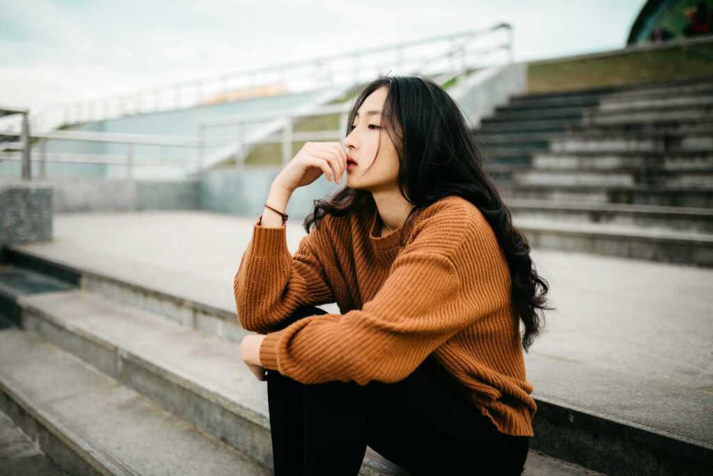 A woman sitting on concrete steps concentrating