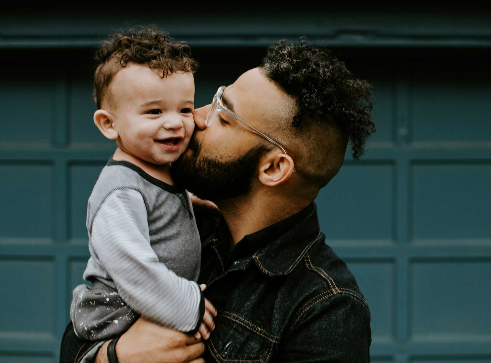kelly sikkema FqqaJI9OxMI unsplash a dad holding his baby and kissing him on the cheek