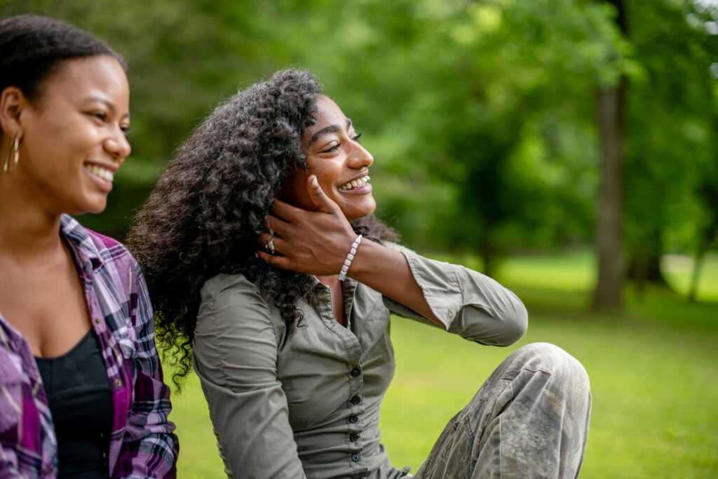 Two women sitting outside smiling