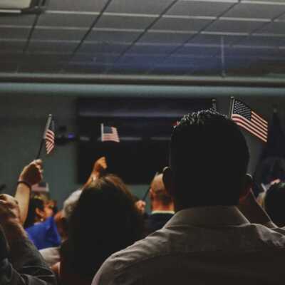 a room of people holding up small American flags